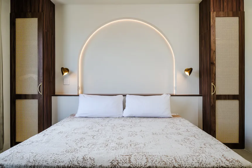 King bed with arched headboard in the Oceanview Suite