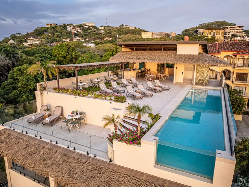 Rooftop pool, lounge and bar above Tamarindo at golden hour