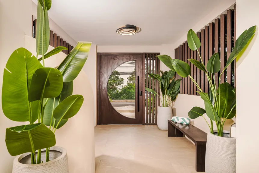 Lobby entrance with round wooden door and tropical plants