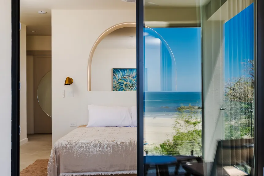 Signature Oceanfront Balcony Suite with ocean view through glass doors