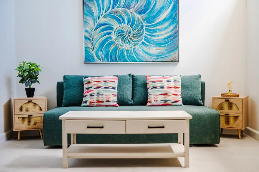 Queen futon sofa beneath ocean art in the Signature Suite