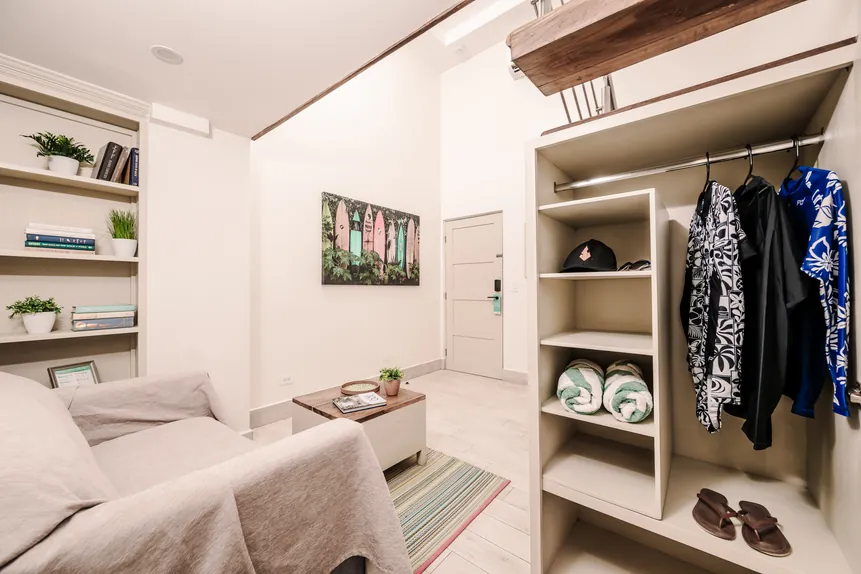 Open closet and lounge chair in the Surf Loft Suite